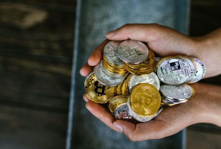 person holding gold and silver coins