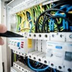 electrician fixing an opened switchboard