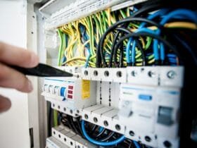 electrician fixing an opened switchboard