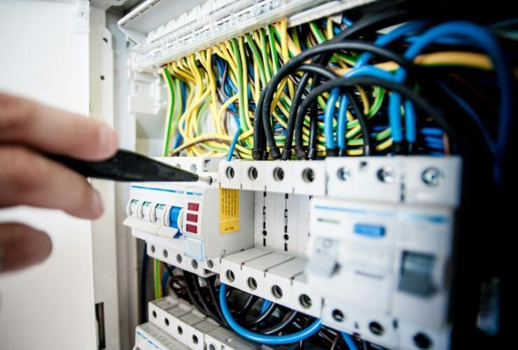 electrician fixing an opened switchboard